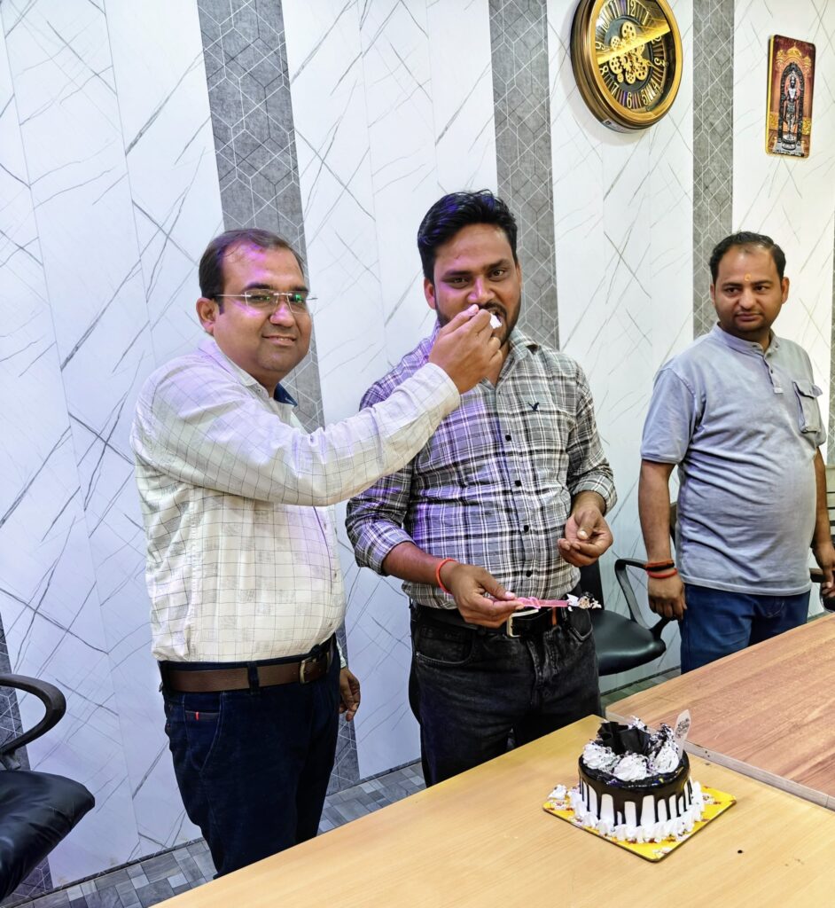 Principal Abhishek Srivastava offering a piece of cake to Manager Hariom Sharma at a celebration in the college office.