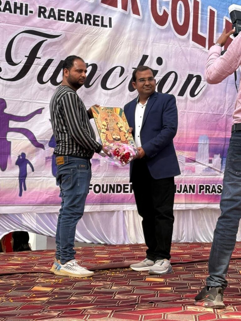 A framed picture and a bouquet presented to a guest on stage in front of the Annual Function banner.