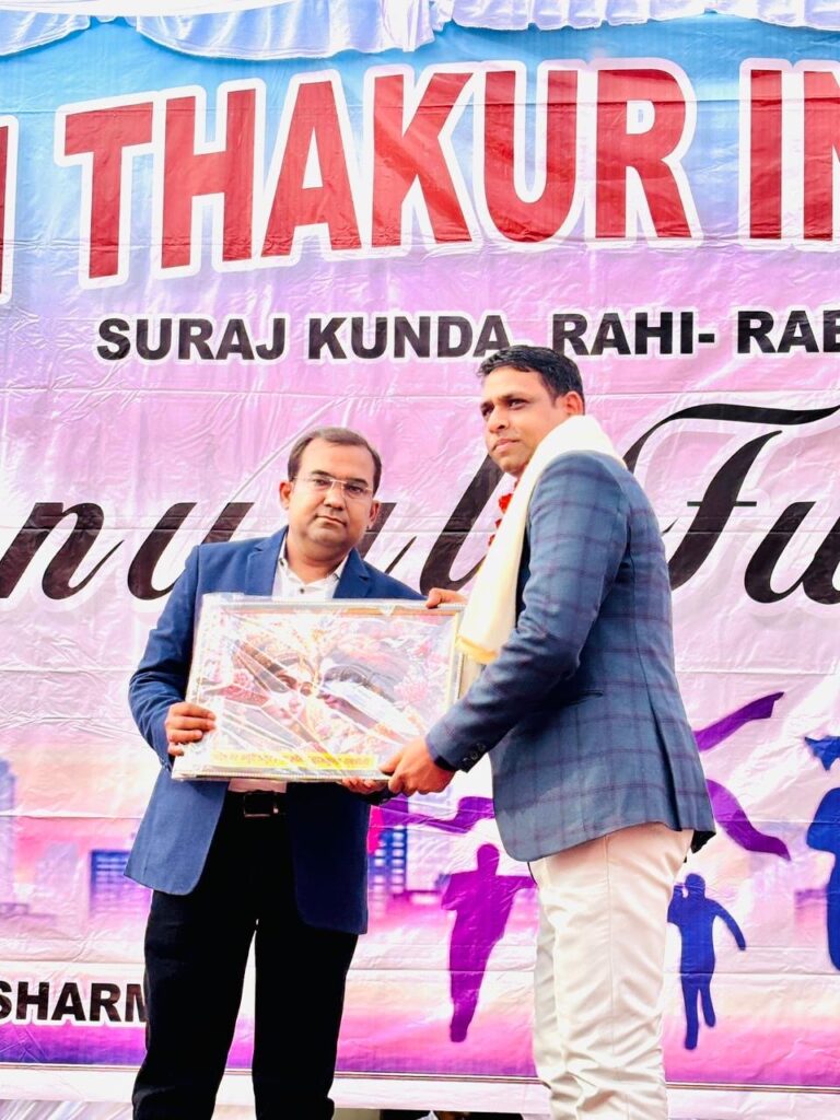 Principal Abhishek Srivastava presenting a framed memento to a guest on stage in front of the Annual Function banner.