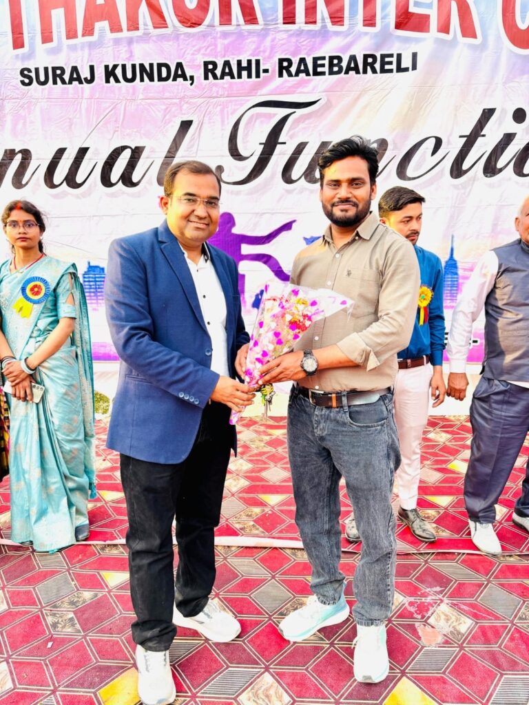 Principal Abhishek Srivastava presenting a bouquet of flowers to a guest on the Annual Function stage, with staff looking on.