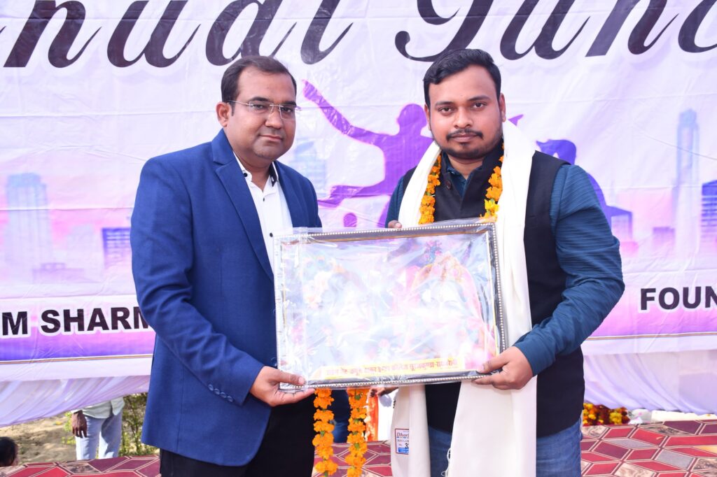 Principal Abhishek Srivastava presenting a framed picture to a garlanded guest wearing a ceremonial shawl at the Annual Function.