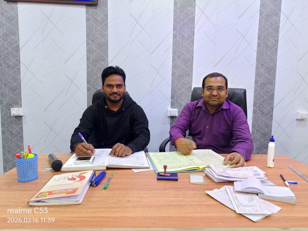 Manager Hariom Sharma and Principal Abhishek Srivastava working side by side at the office desk over the school registers.
