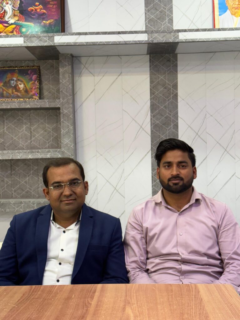 Principal Abhishek Srivastava and Manager Hariom Sharma seated together at the office desk.