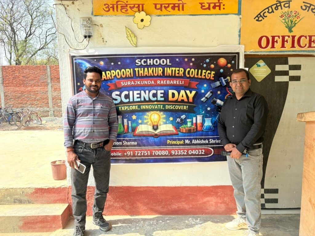 Two staff members standing beside the Science Day banner outside the office at Karpoori Thakur Inter College, Surajkunda