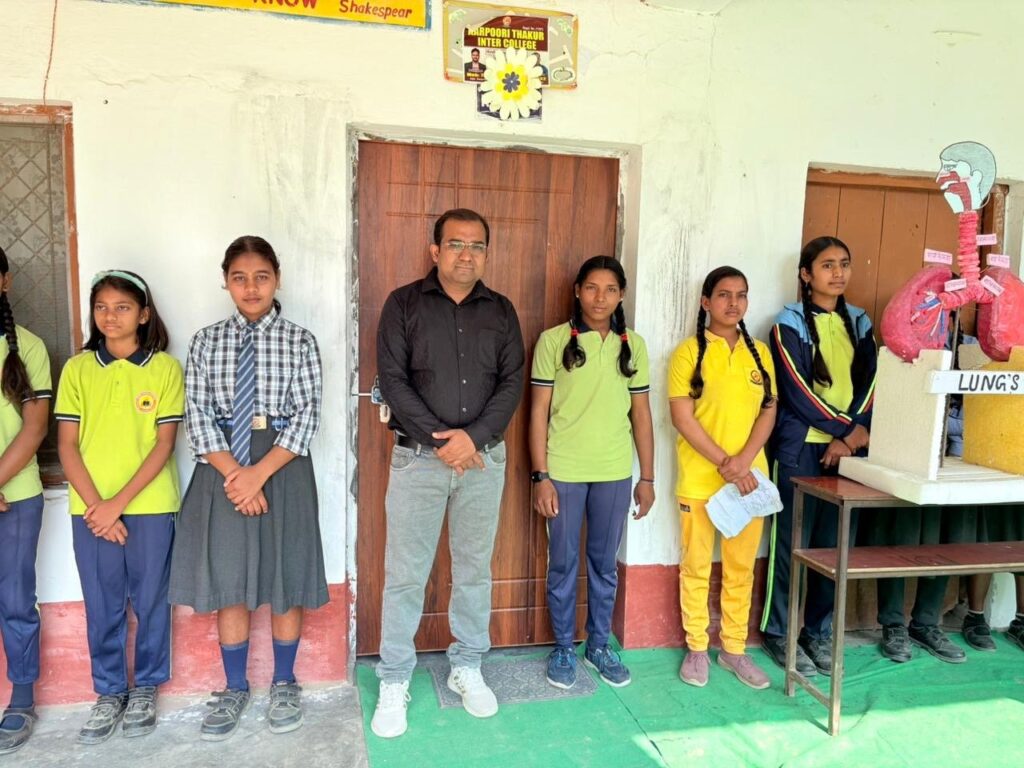 Students in school uniform standing with a teacher beside a hand-made model of the lungs on Science Day