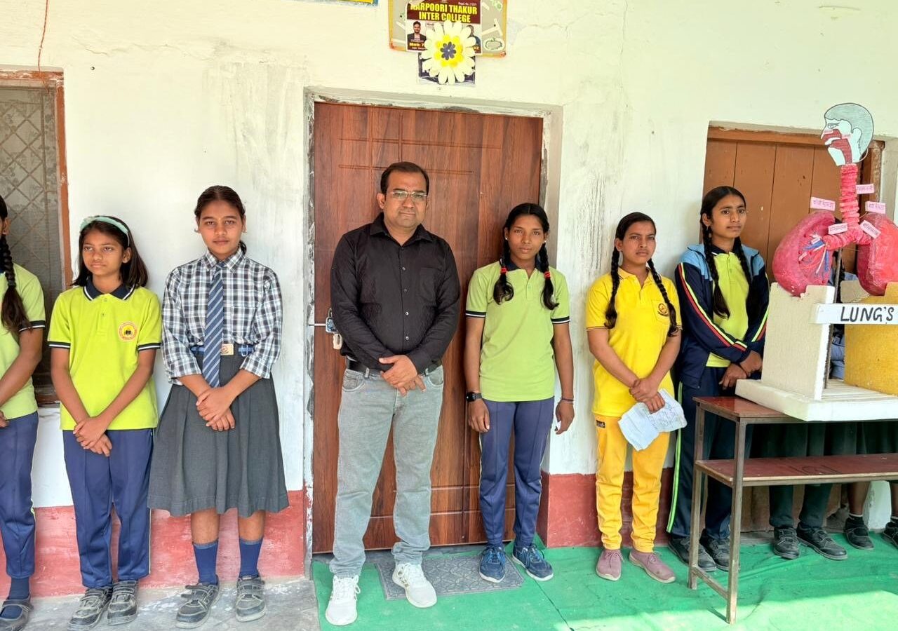 Students in school uniform standing with a teacher beside a hand-made model of the lungs on Science Day