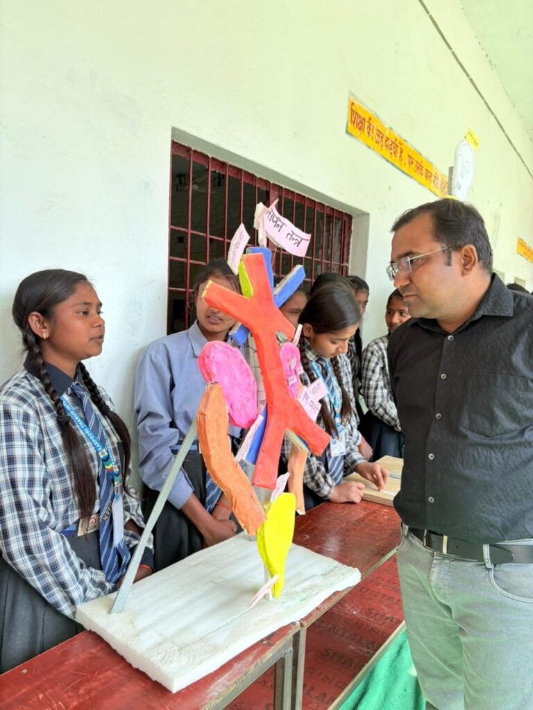 Students presenting a hand-made painted model of the muscles and limbs to a teacher at the Science Day exhibition