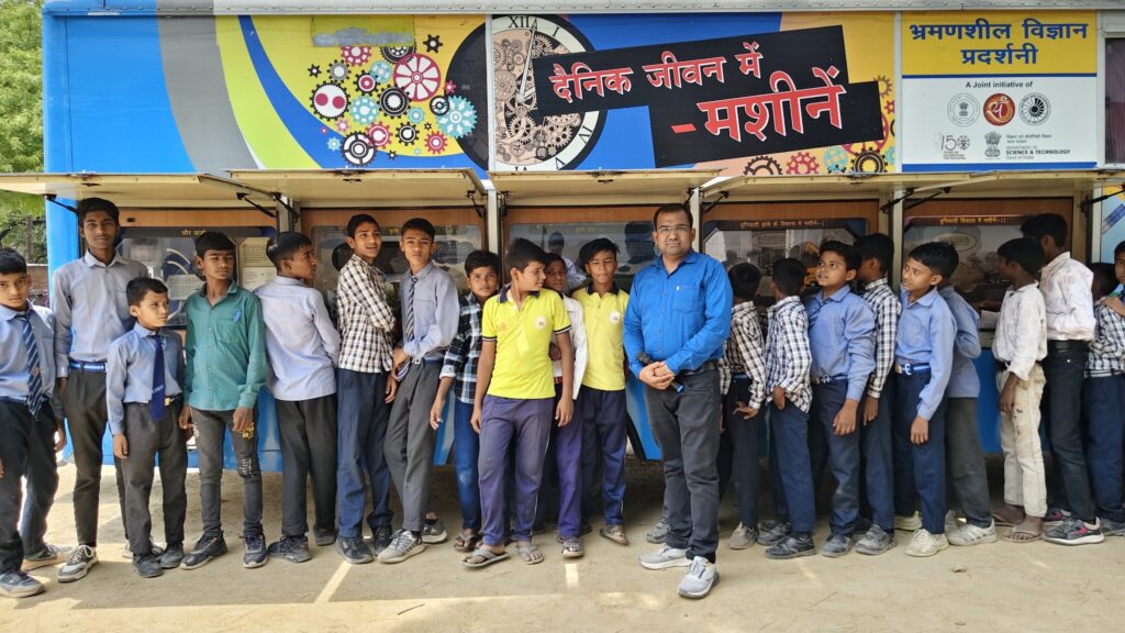 Students queuing along the open display panels of the Department of Science and Technology mobile science exhibition van on the theme Machines in Daily Life