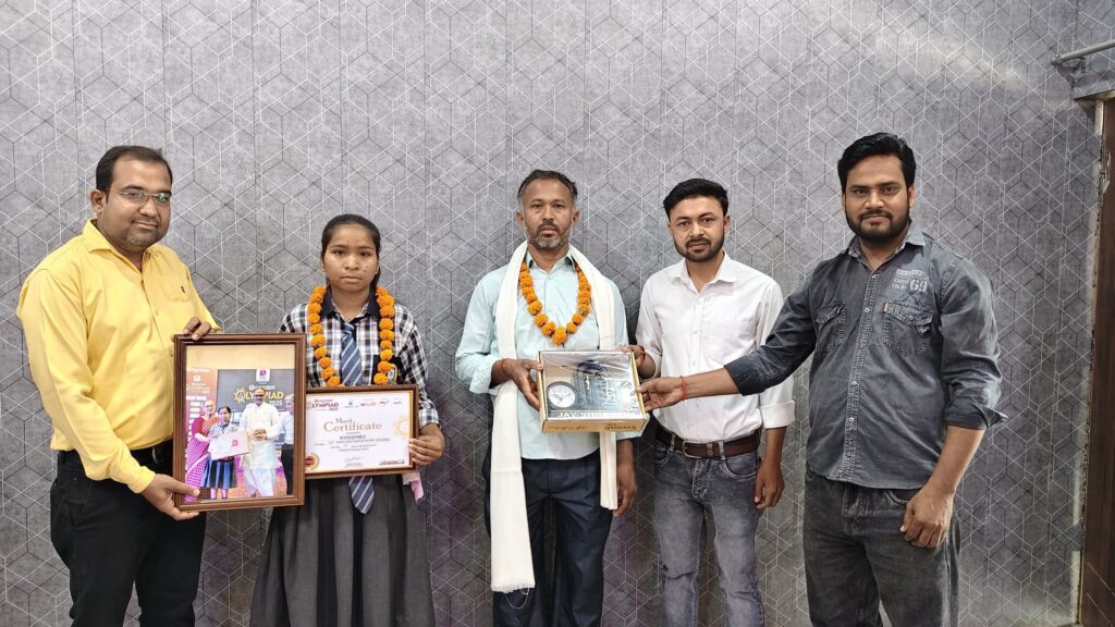 Principal Abhishek Srivastava, a garlanded student holding a merit certificate, her garlanded father and college staff standing together for a felicitation photograph.