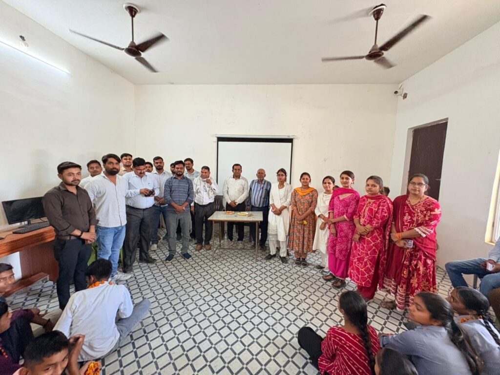 Teachers standing with students seated on the floor during a gathering in a college classroom